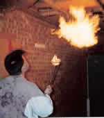 Martin learning firebreathing in his garage in order to be seen from the back at the upcomming Kingston festival, 1992